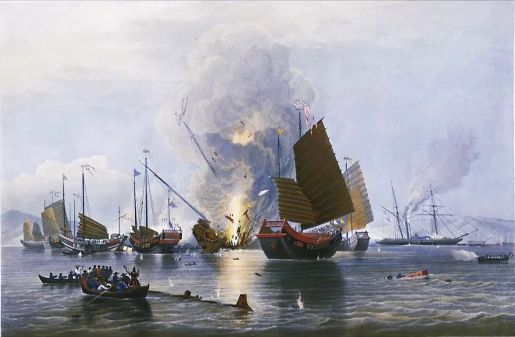 British and Chinese vessels fill a bay as an exploding Chinese war junk throws flame, timber, and smoke into the sky; people cling to debris in the foreground while the iron steamship Nemesis stands at right.