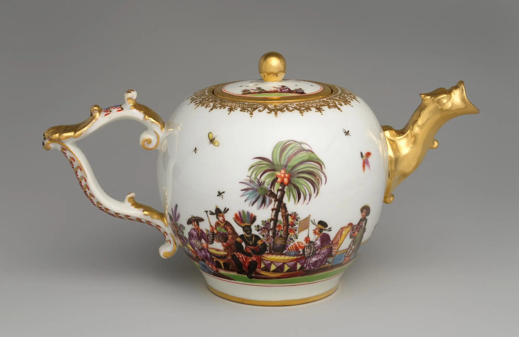 A white Meissen porcelain teapot with gold handle and spout, brightly coloured chinoiserie figures, palms, insects, and flowers.